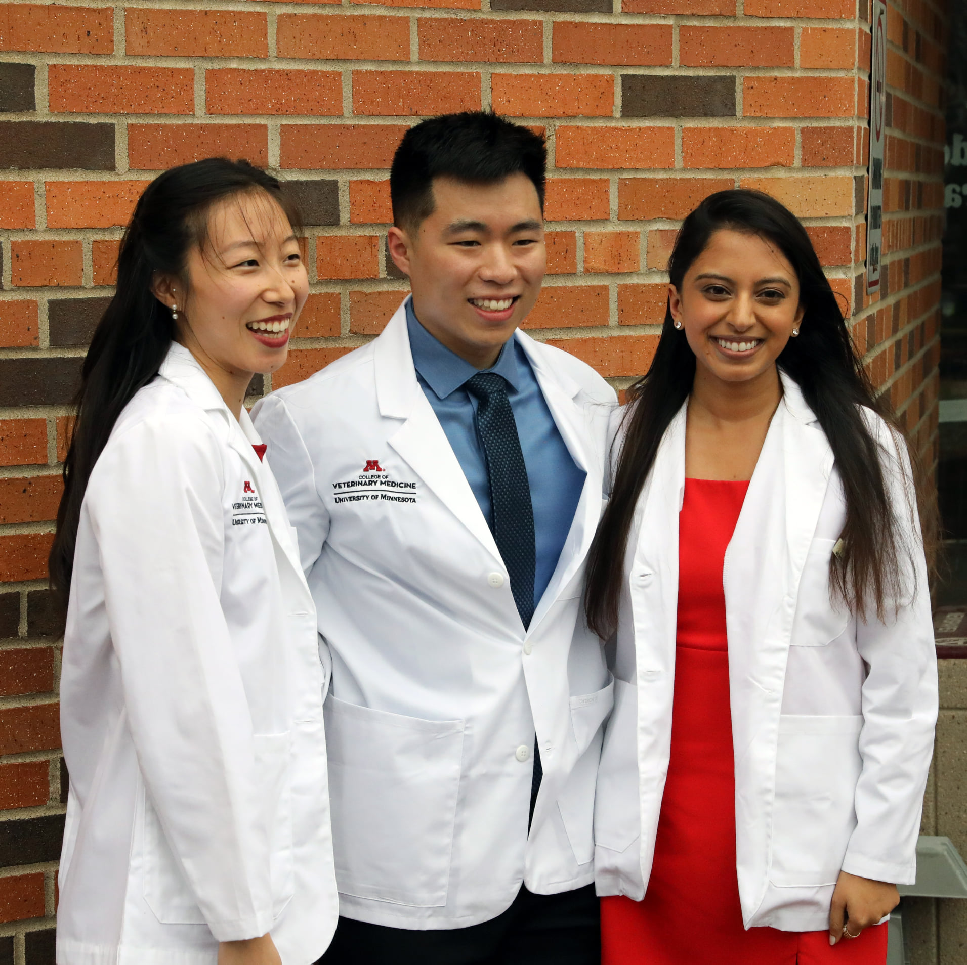 Whitecoat ceremony 2022 - students pose outside in front of brick wall
