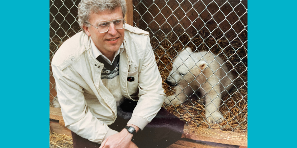 Dr. David Hall sits with a polar bear cub. 