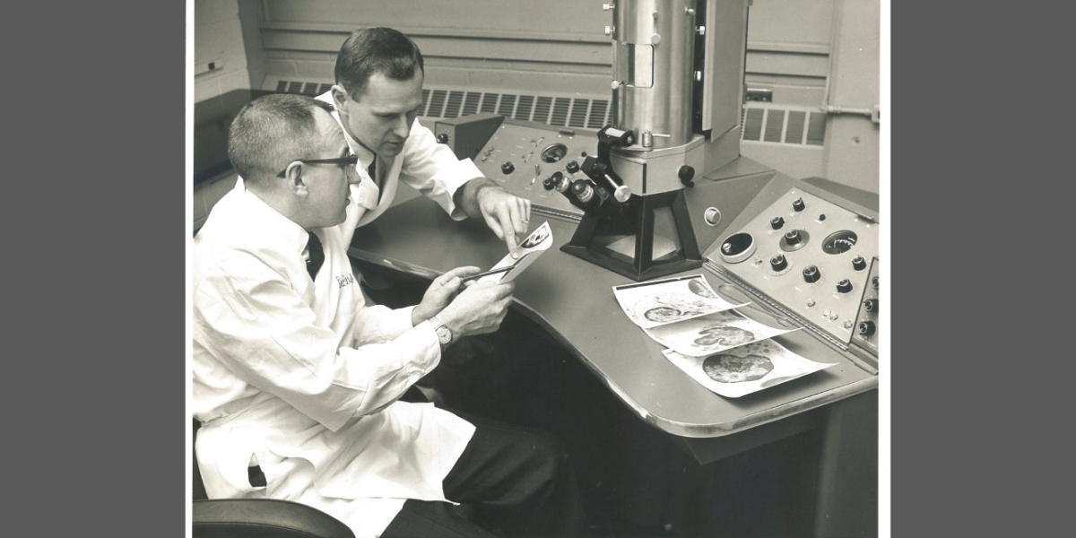 Dr. Terrance O’Leary (right) discussing an electron micrograph with Dr. Al Weber