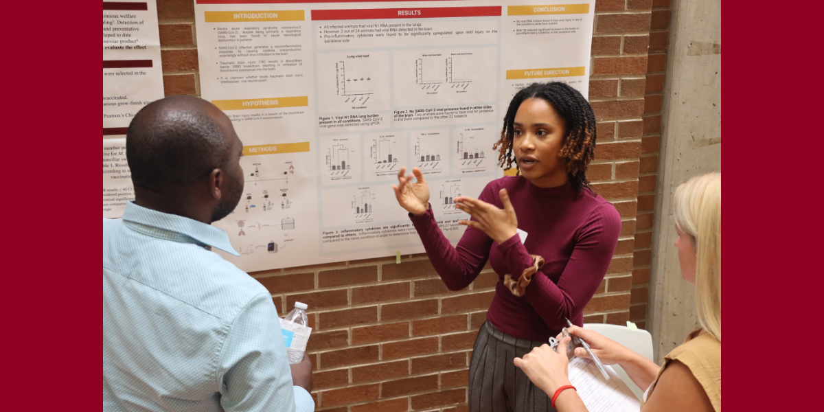 CVM student Calah Sewell discusses her research poster topic with attendees of the RIDE Summit. 