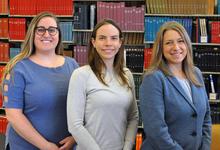 Emma Leof Bollig, Dr. Amanda Beaudoin, and Dr. Jennifer Granick pose in front of bookcase