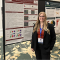 Caitlyn Callaghan stands next to her research poster